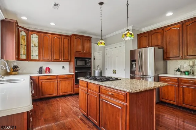 a kitchen with stainless steel appliances granite countertop a sink refrigerator and cabinets