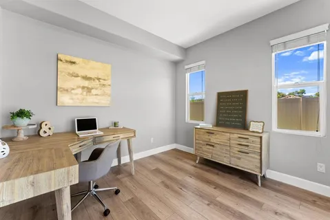 a view of a workspace with furniture and a window