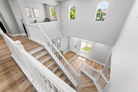 a view of a hallway with wooden floor and stairs