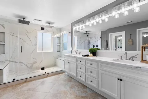 a spacious bathroom with double sink and a mirror