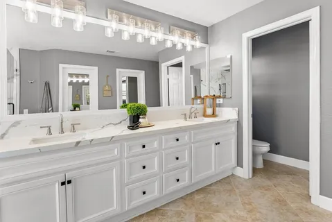 a bathroom with double sink and a mirror