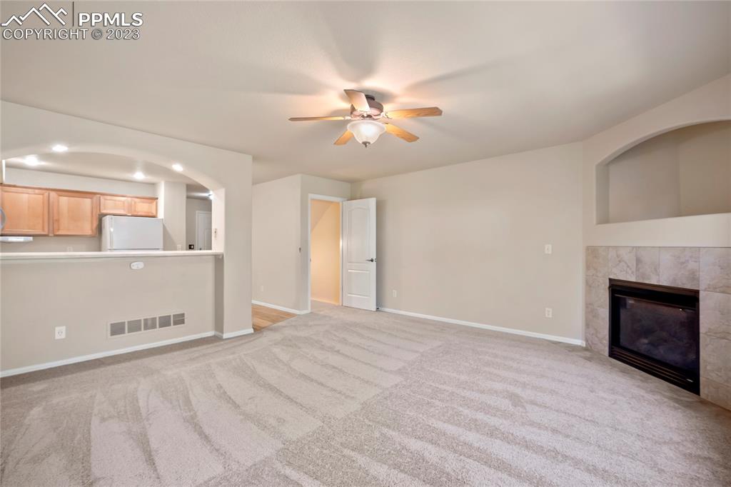 3822 Homestead Ridge Heights Colorado Springs, CO 80917 - Photo 2 of 17 a view of a kitchen with a fireplace a ceiling fan and wooden floor