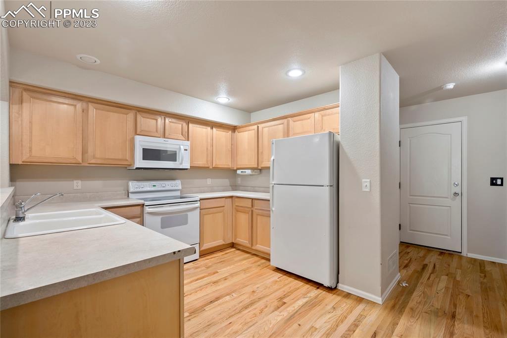 3822 Homestead Ridge Heights Colorado Springs, CO 80917 - Photo 4 of 17 a kitchen with a refrigerator sink and cabinets