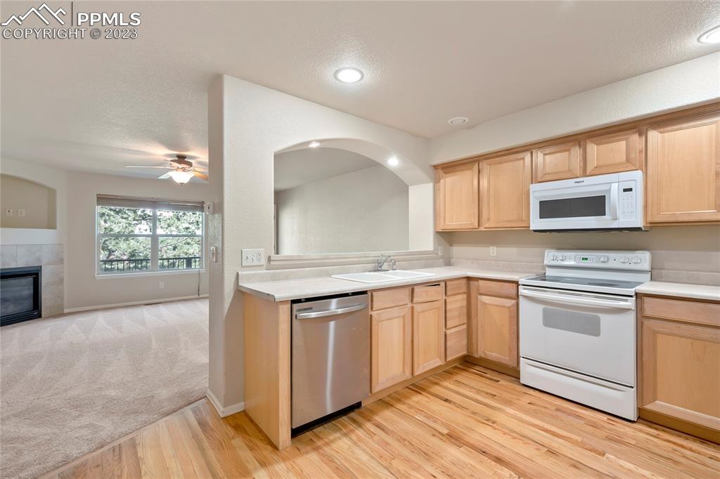 3822 Homestead Ridge Heights Colorado Springs, CO 80917 - Photo 6 of 17 a kitchen with stainless steel appliances granite countertop a stove a sink and a microwave