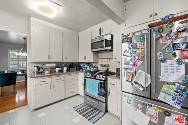 a kitchen with stainless steel appliances granite countertop a refrigerator and a stove top oven
