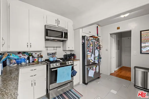 a kitchen with stainless steel appliances granite countertop a stove and cabinets