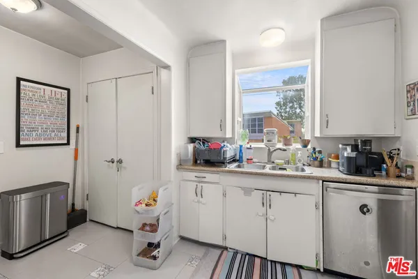 a kitchen with white cabinets and sink