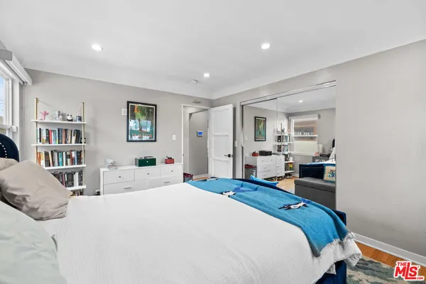 a bedroom with a bed and a large mirror