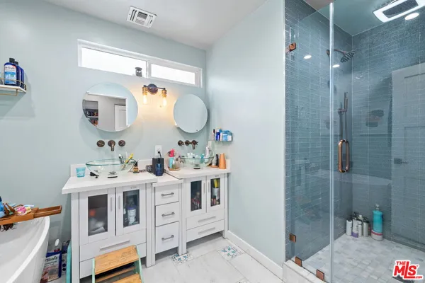 a bathroom with a double vanity sink mirror and shower