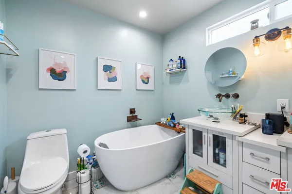 a bathroom with a toilet a sink and a mirror