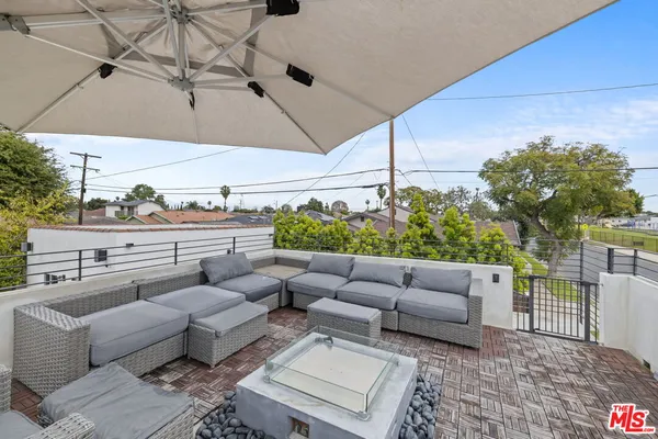 a roof deck with couches and potted plant