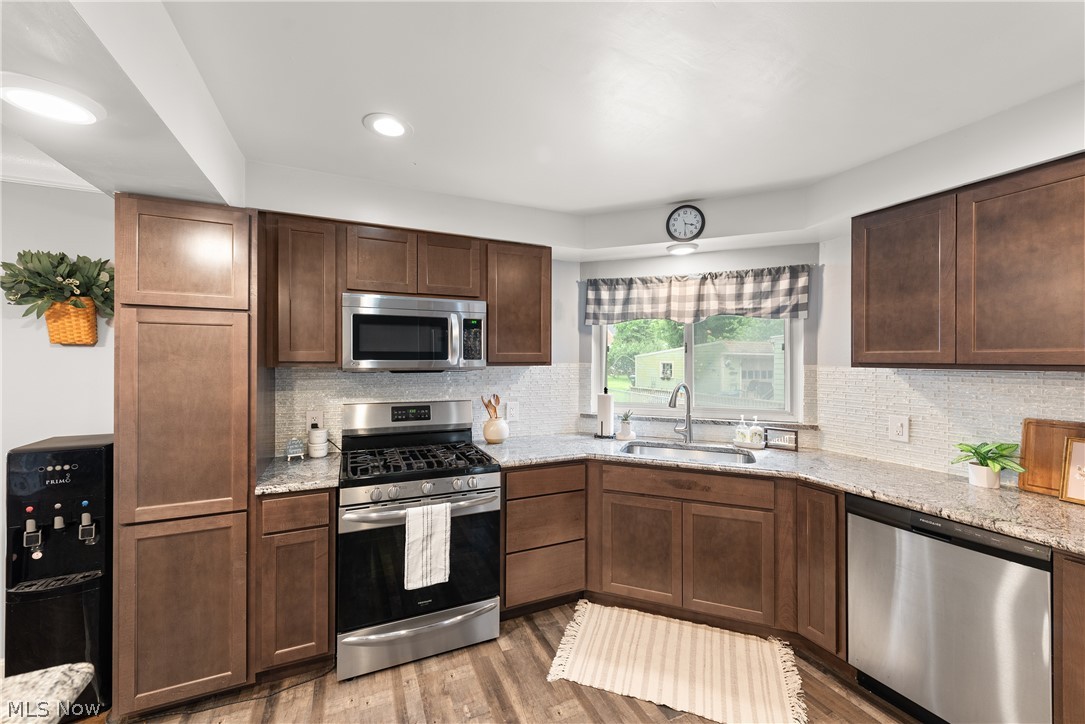 21779 Eaton Road Cleveland, OH 44126 - Photo 10 of 46 Kitchen with sink, light wood-type flooring, light stone counters, and stainless steel appliances