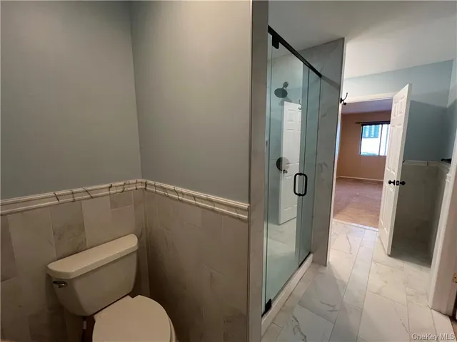 a bathroom with a granite countertop toilet and a shower