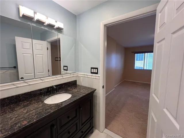 a bathroom with a granite countertop sink and a mirror