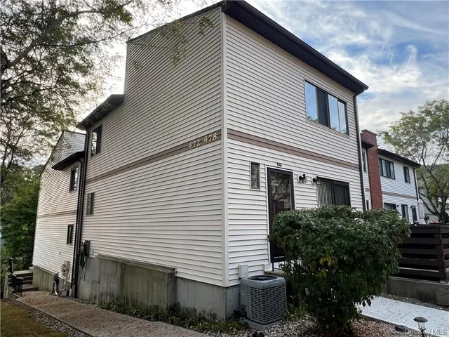 a view of a white house with many windows and potted plants