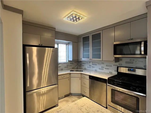 a kitchen with stainless steel appliances granite countertop a refrigerator stove and microwave