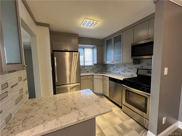 a kitchen with granite countertop a refrigerator and a sink