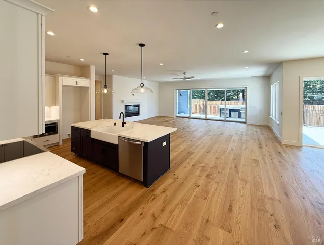 a large room with kitchen island a wooden floor and white appliances