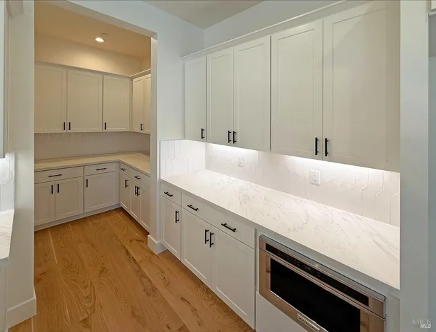 a view of a kitchen with white cabinets