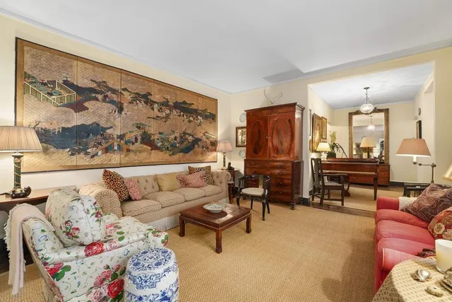 a living room with furniture a rug and a wall painting