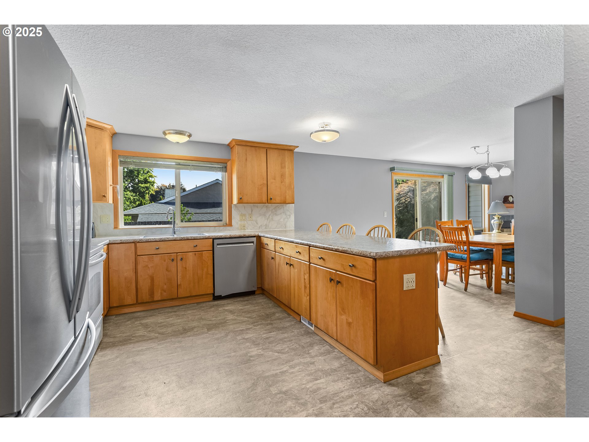 9630 Southwest Robbins Drive Beaverton, OR 97008 - Photo 15 of 35 a kitchen with stainless steel appliances a sink and a refrigerator