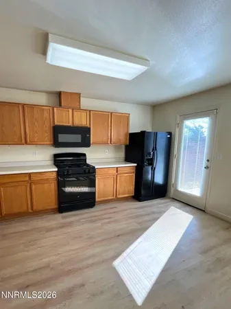 a kitchen with stainless steel appliances kitchen island granite countertop a refrigerator cabinets and wooden floor