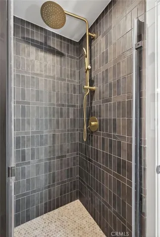 a bedroom with a bed a couch and a dresser with wooden floor