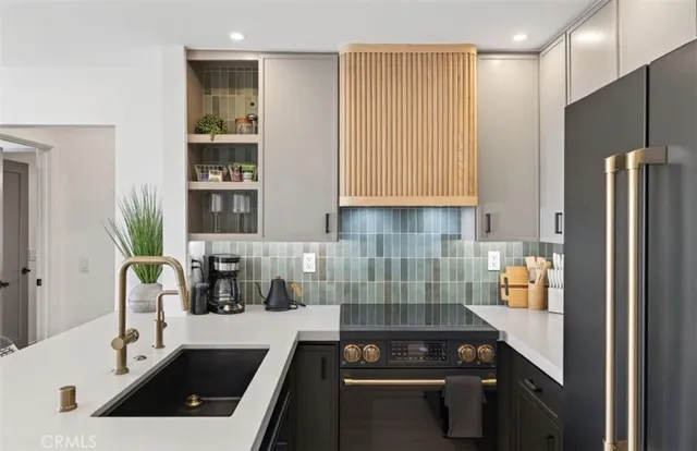 a kitchen with a sink a refrigerator and cabinets