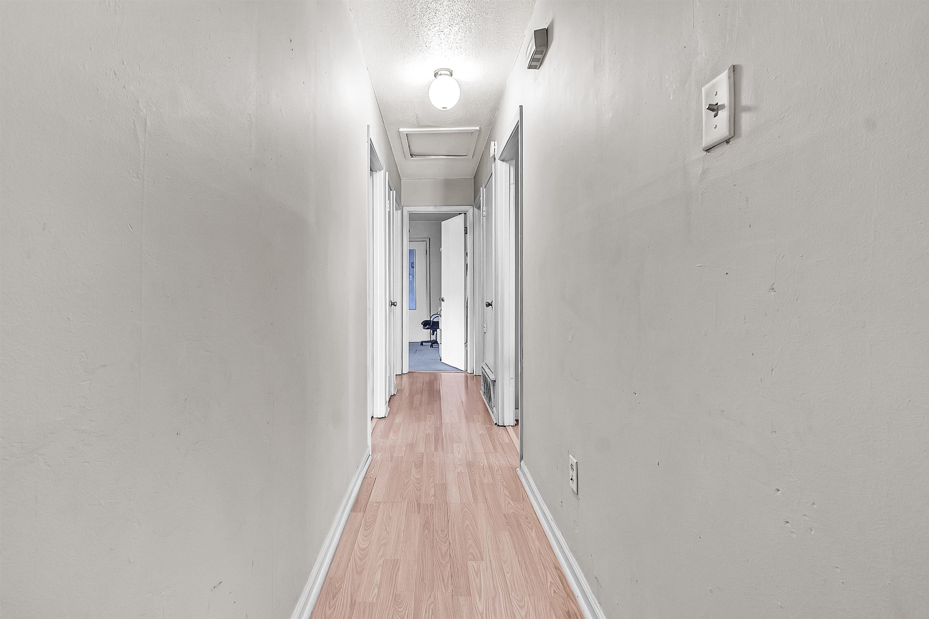 a view of a hallway with wooden floor