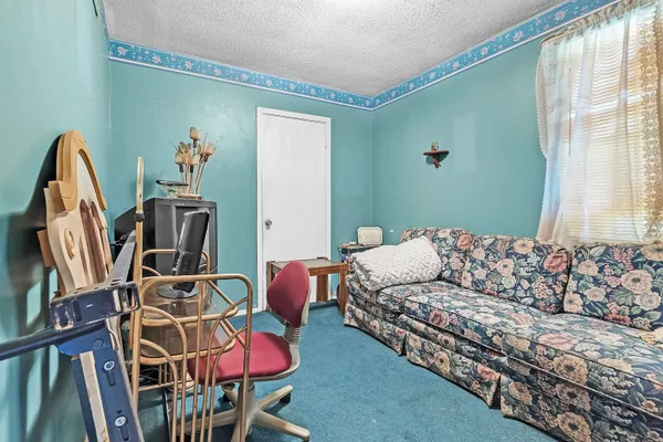 a living room with furniture a flat screen tv and a window