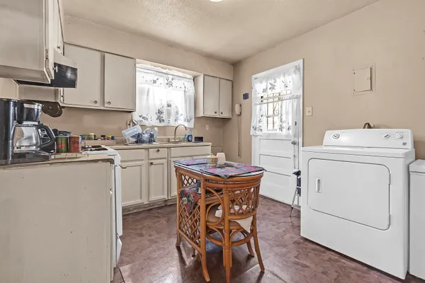 a kitchen with a stove a sink cabinets and a window