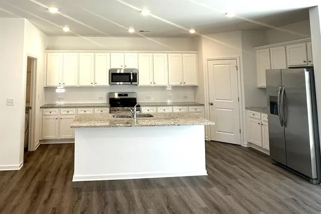 a kitchen with stainless steel appliances granite countertop a sink stove and microwave