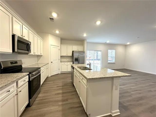 a view of kitchen with kitchen island sink refrigerator and window