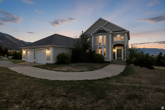 2887 View Crest Circle North Logan, UT 84341 - Photo 2 of 37 View of front of property featuring a mountain view, an attached garage, a yard, concrete driveway, and stucco siding