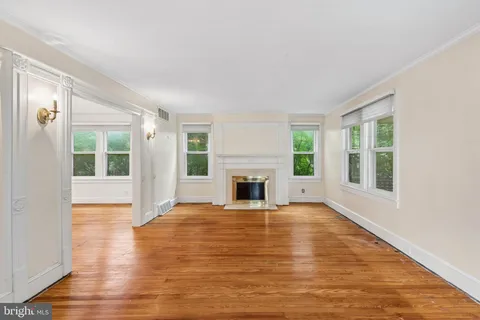 a view of an empty room with window and fire place