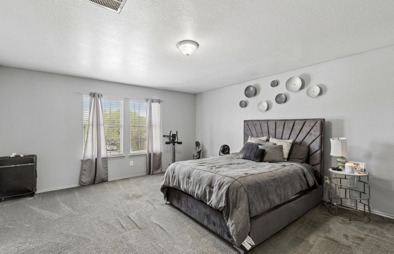 7118 Rising Brook Drive Cypress, TX 77433 - Photo 12 of 21 a bedroom with a bed a couch and large window with garden view