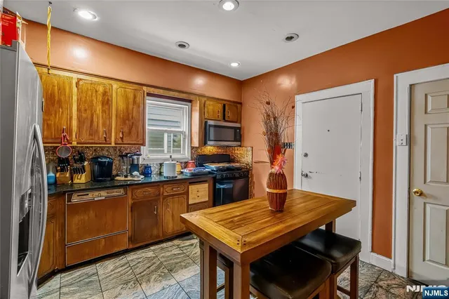 a kitchen with stainless steel appliances granite countertop a stove refrigerator sink and cabinets