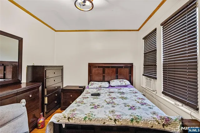 a bedroom with a bed and a flat tv screen on dresser