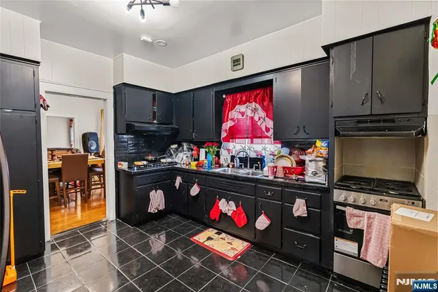 a kitchen with stainless steel appliances kitchen island granite countertop a refrigerator stove and sink