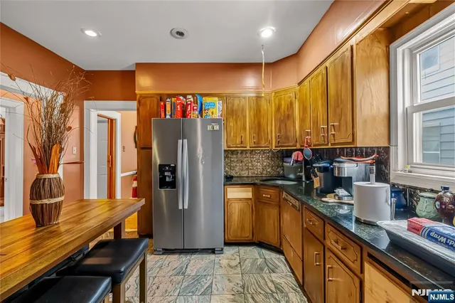 a kitchen with stainless steel appliances granite countertop sink stove refrigerator and cabinets