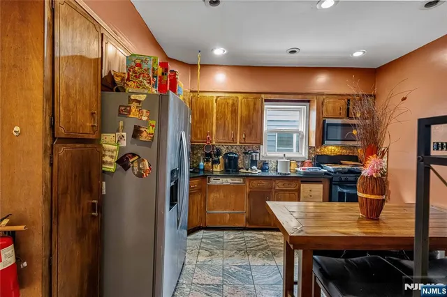 a kitchen with stainless steel appliances granite countertop a refrigerator and a stove