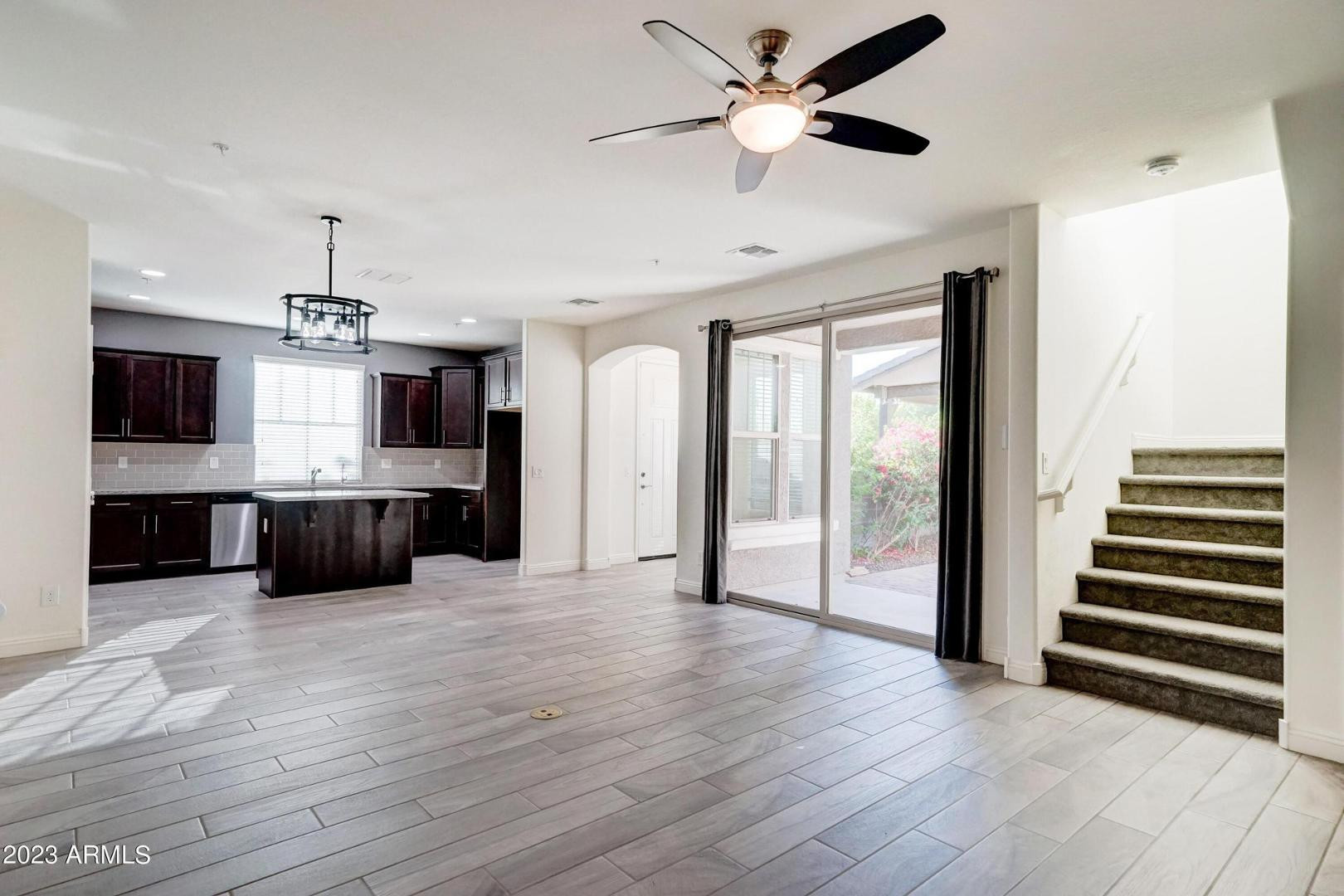 2297 North Alsap Road Buckeye, AZ 85396 - Photo 5 of 36 wooden floor in an empty room with a window and a kitchen