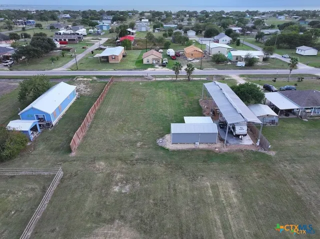an aerial view of a house with a yard and lake view