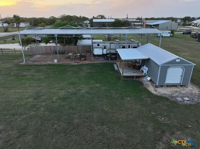 a view of a backyard with table and chairs under an umbrella
