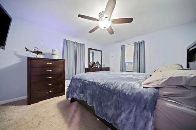 a bedroom with a bed and a ceiling fan