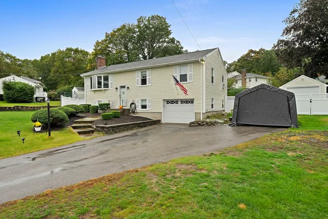 a view of a house with backyard and trees