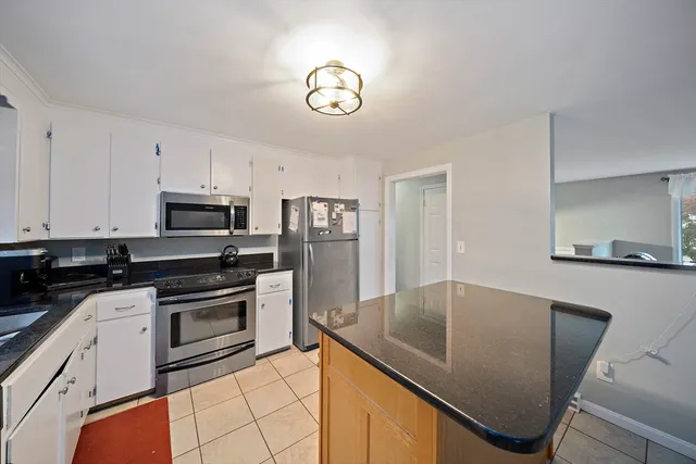 a kitchen with stainless steel appliances granite countertop a refrigerator a stove microwave and sink