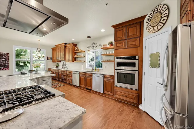 a kitchen with stainless steel appliances granite countertop a stove and a refrigerator