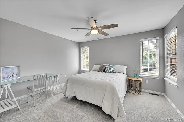 a bedroom with a bed a chandelier and a window
