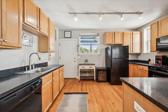 a kitchen with granite countertop a refrigerator stove and sink